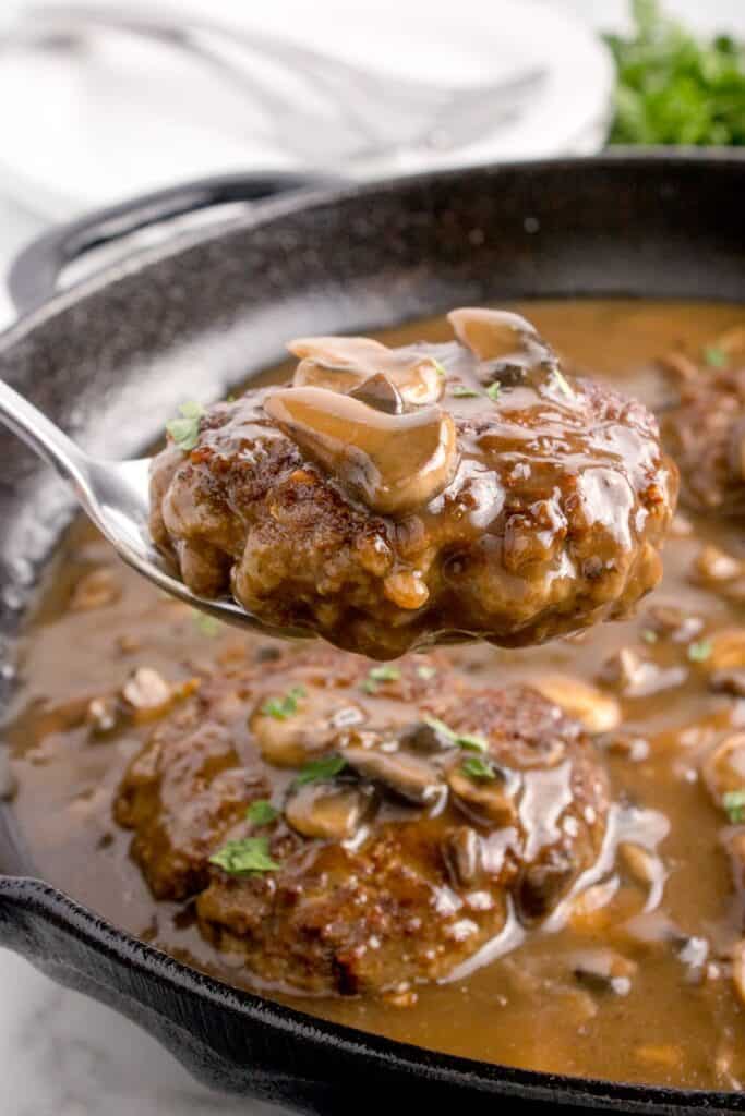 scooping up a ground beef steak with mushroom gravy