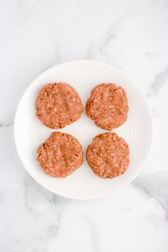 flattened salisbury steak patties on a white plate