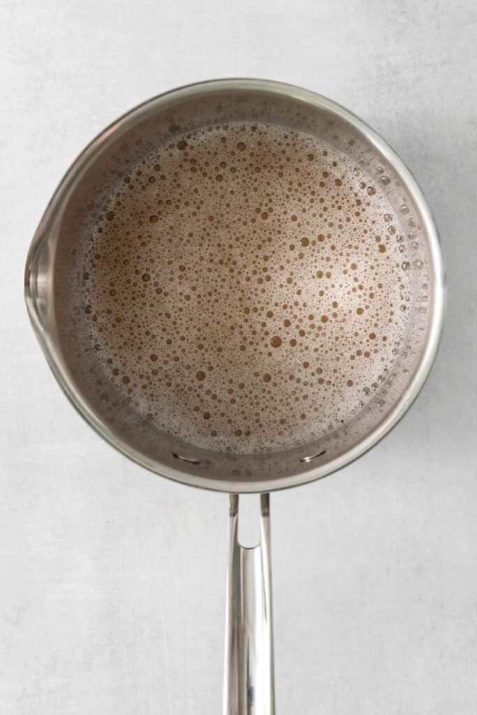Apple cider, water, and gelatin in a pot to make a homemade apple pie.