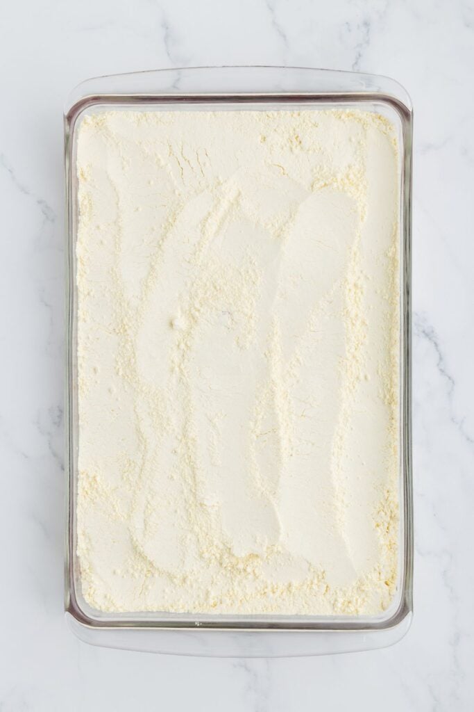 adding yellow cake mix over cherry pie filling