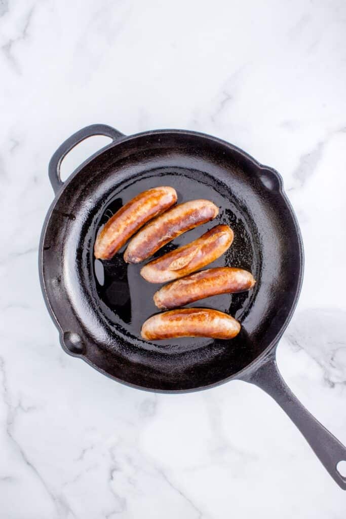 searing mild Italian sausages in hot cast iron skillet.