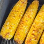 Air fryer corn on the cob cooked inside an air fryer basket.