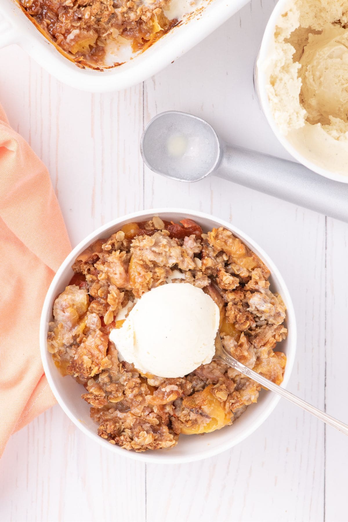 a bowl of peach crisp and ice cream