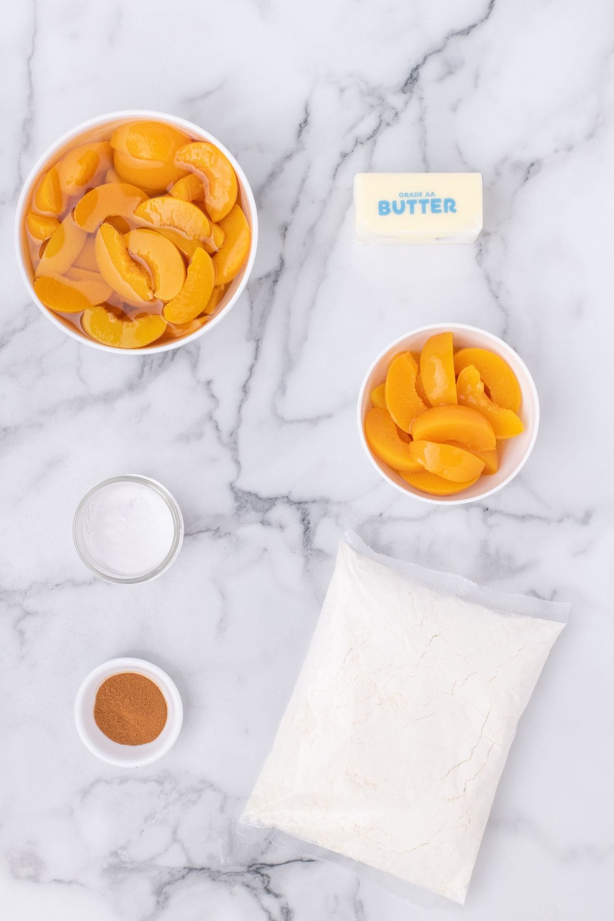 Ingredients needed to make peach cobbler: cake mix, canned peaches, butter, salt, and cinnamon.