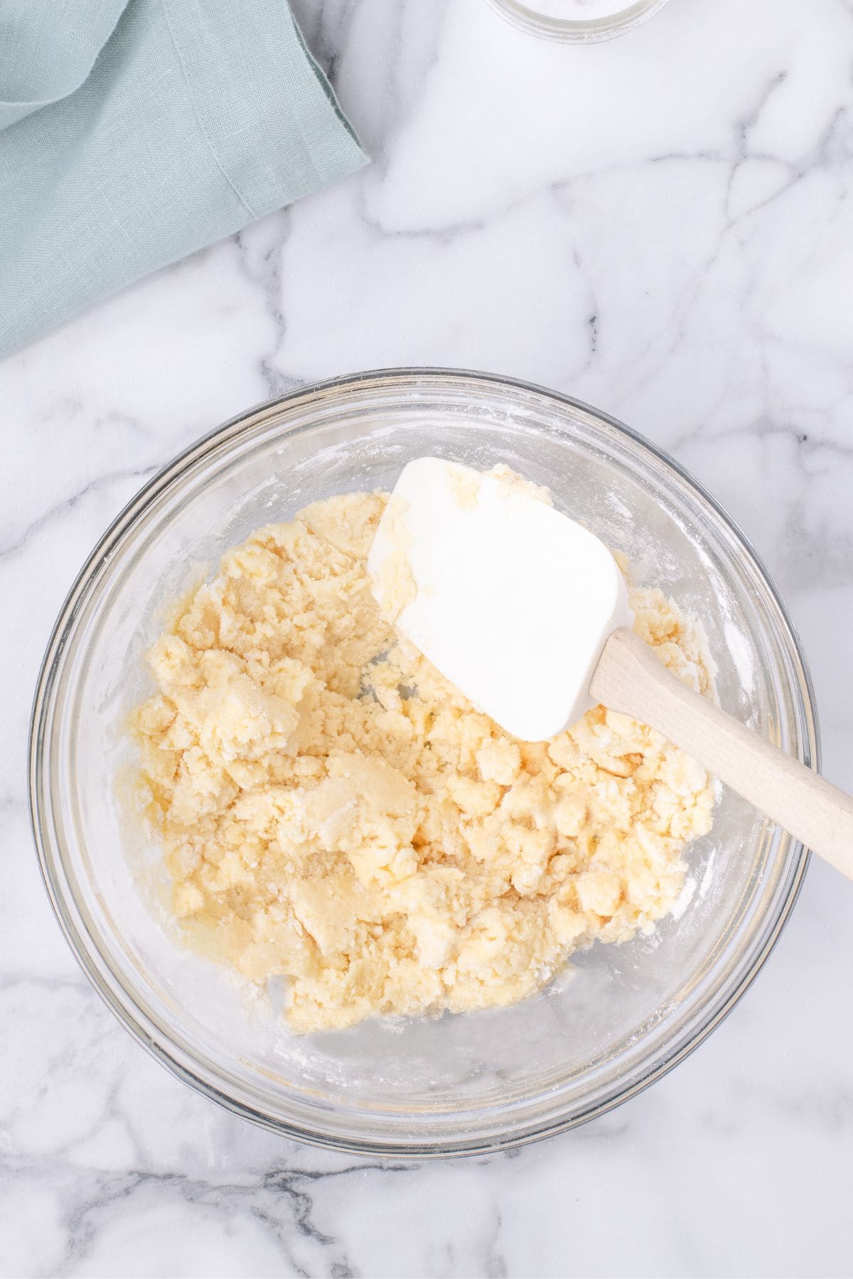 The butter, cake mix, and cinnamon mixed to show a crumbly topping in a bowl.
