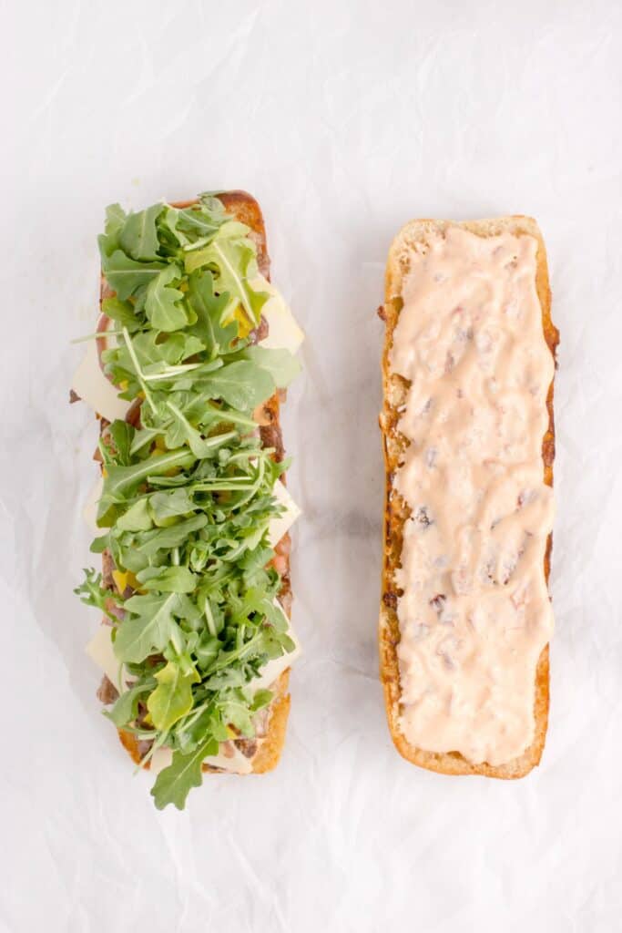 adding fresh arugula to steak sandwich recipe