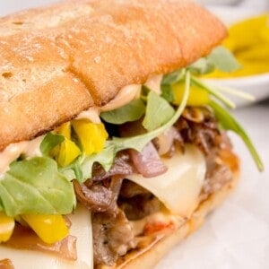 closed steak sandwich with toppings