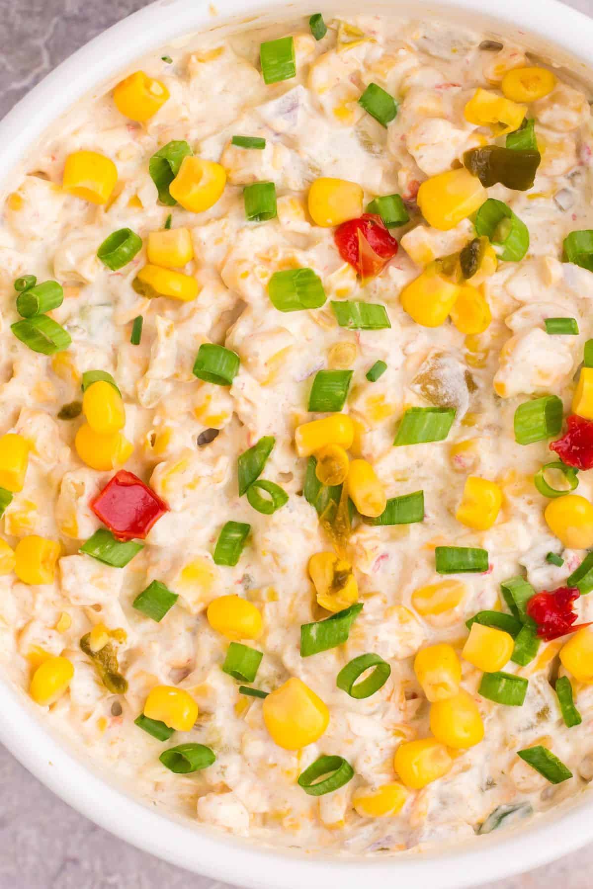 Close up of the corn dip with fritos in a serving bowl.