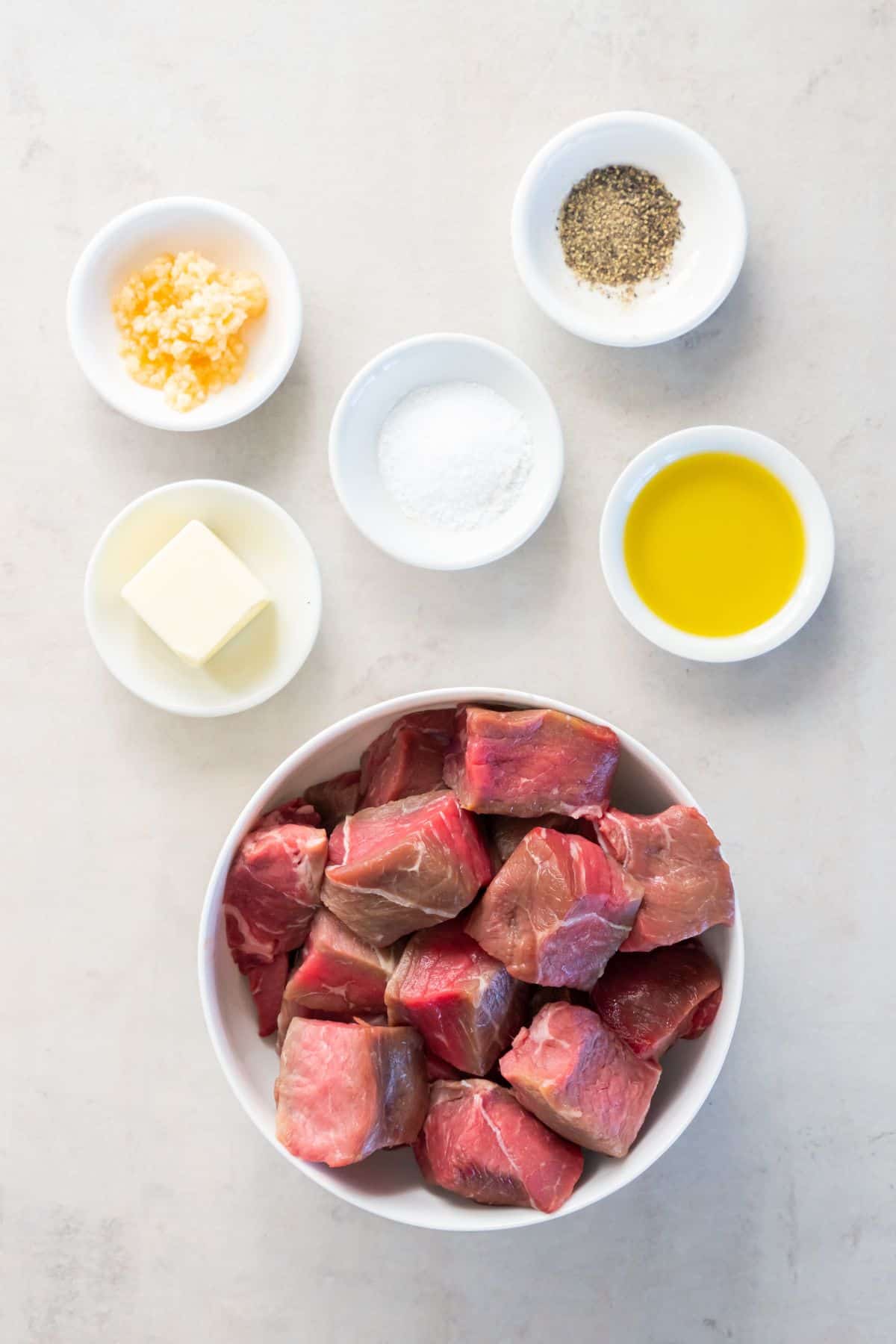 Ingredients needed to make steak bites in the air fryer: sirloin steak, oil, butter, garlic, salt, and pepper.