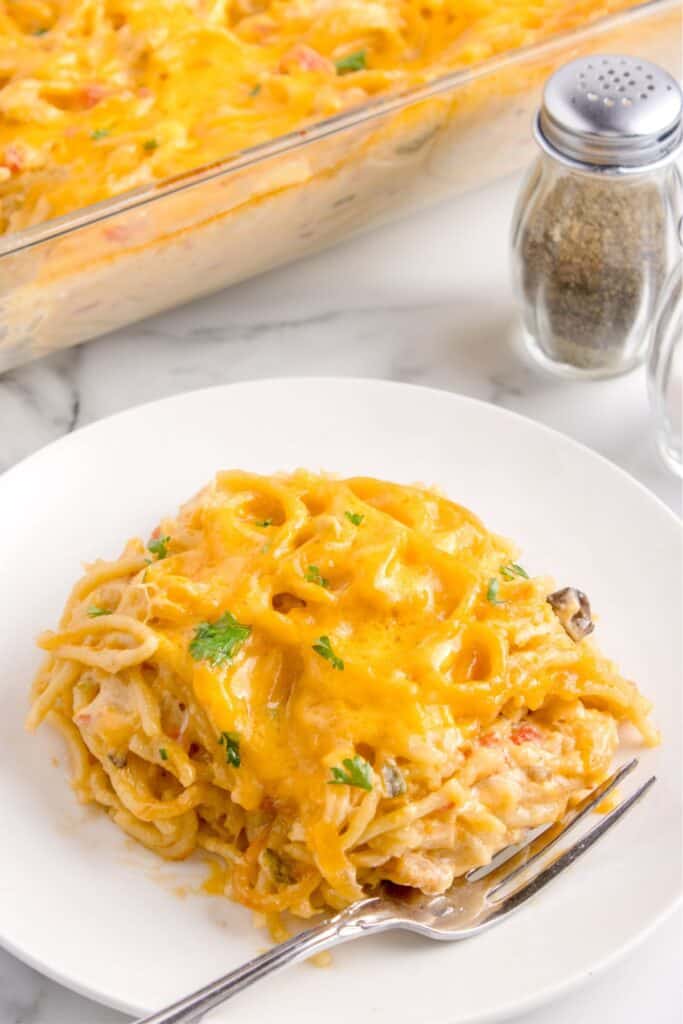 A scoop of Rotel chicken spaghetti on a white plate, ready to be eaten.