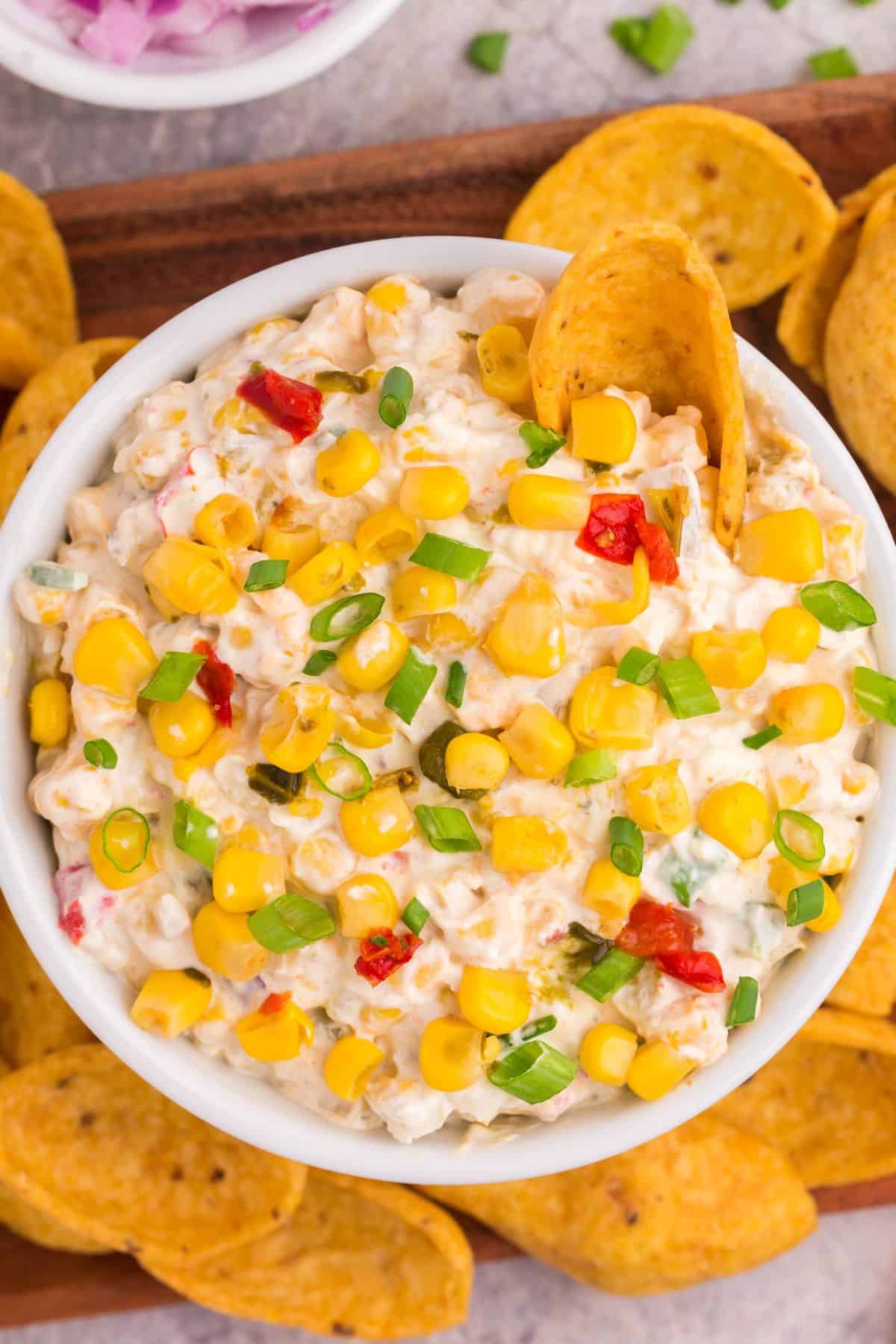 Overhead view of corn dip with fritos in it.