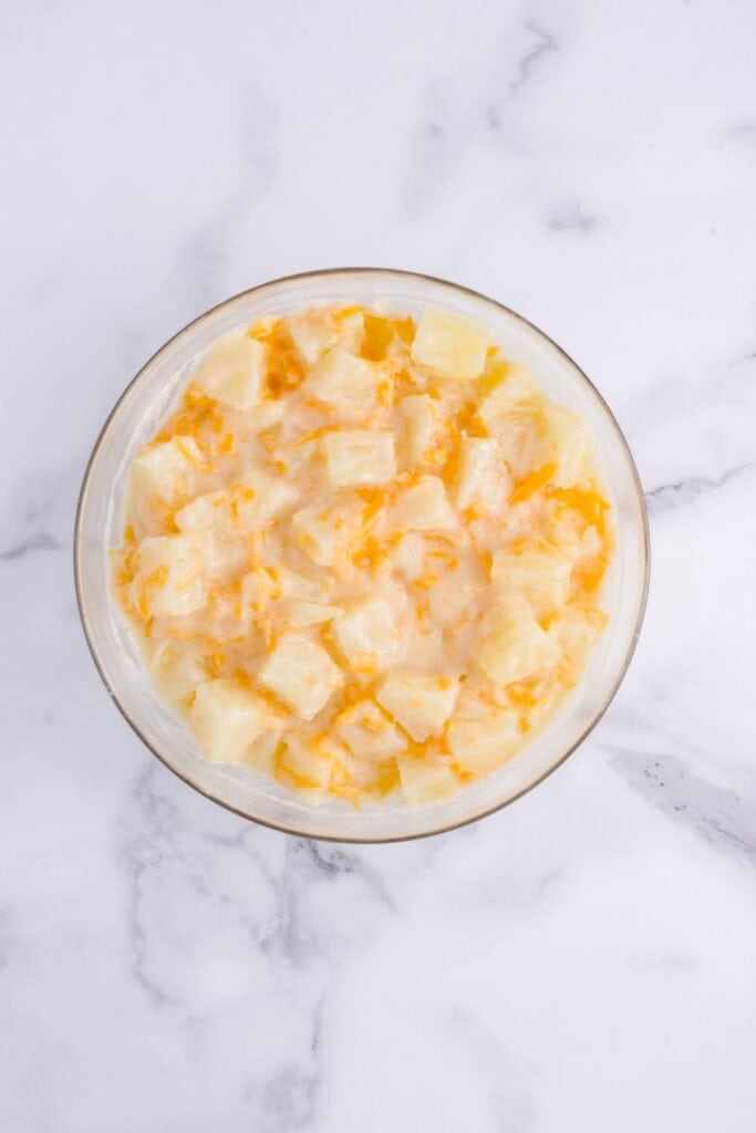 Pineapple casserole mixture of canned pineapple, cheddar cheese, sugar, flour, and butter.