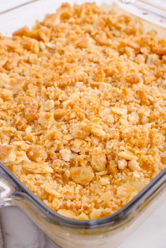 Pineapple casserole in a baking dish with crushed Ritz crackers on top.