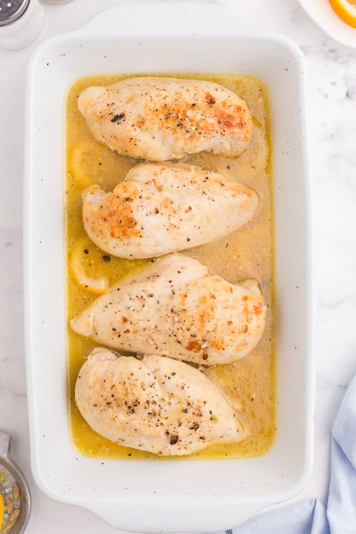 Baked lemon chicken right out of the oven in a serving dish.