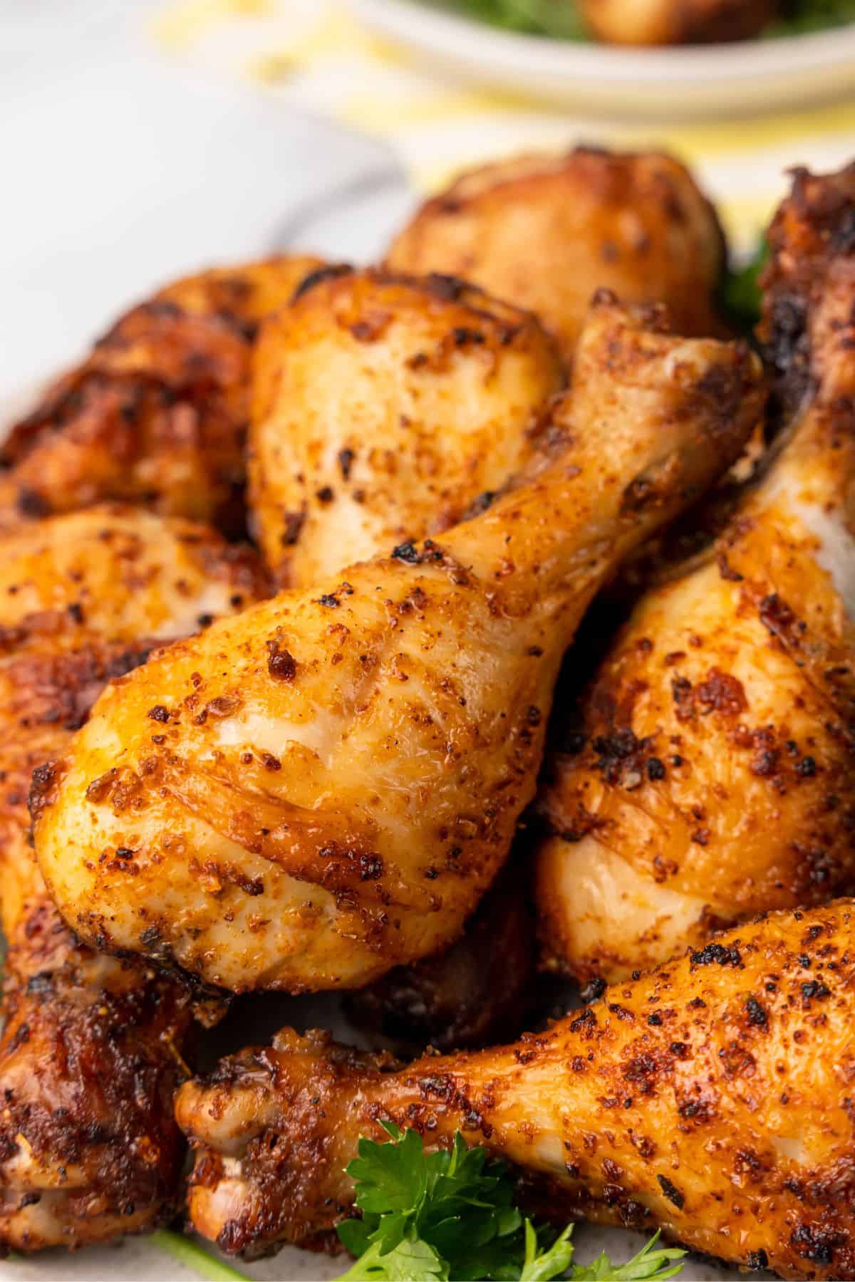 Closeup of the air fryer chicken legs to see the golden brown skin on them.