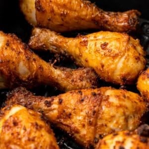 Closeup of the chicken legs in the air fryer basket all done air frying.