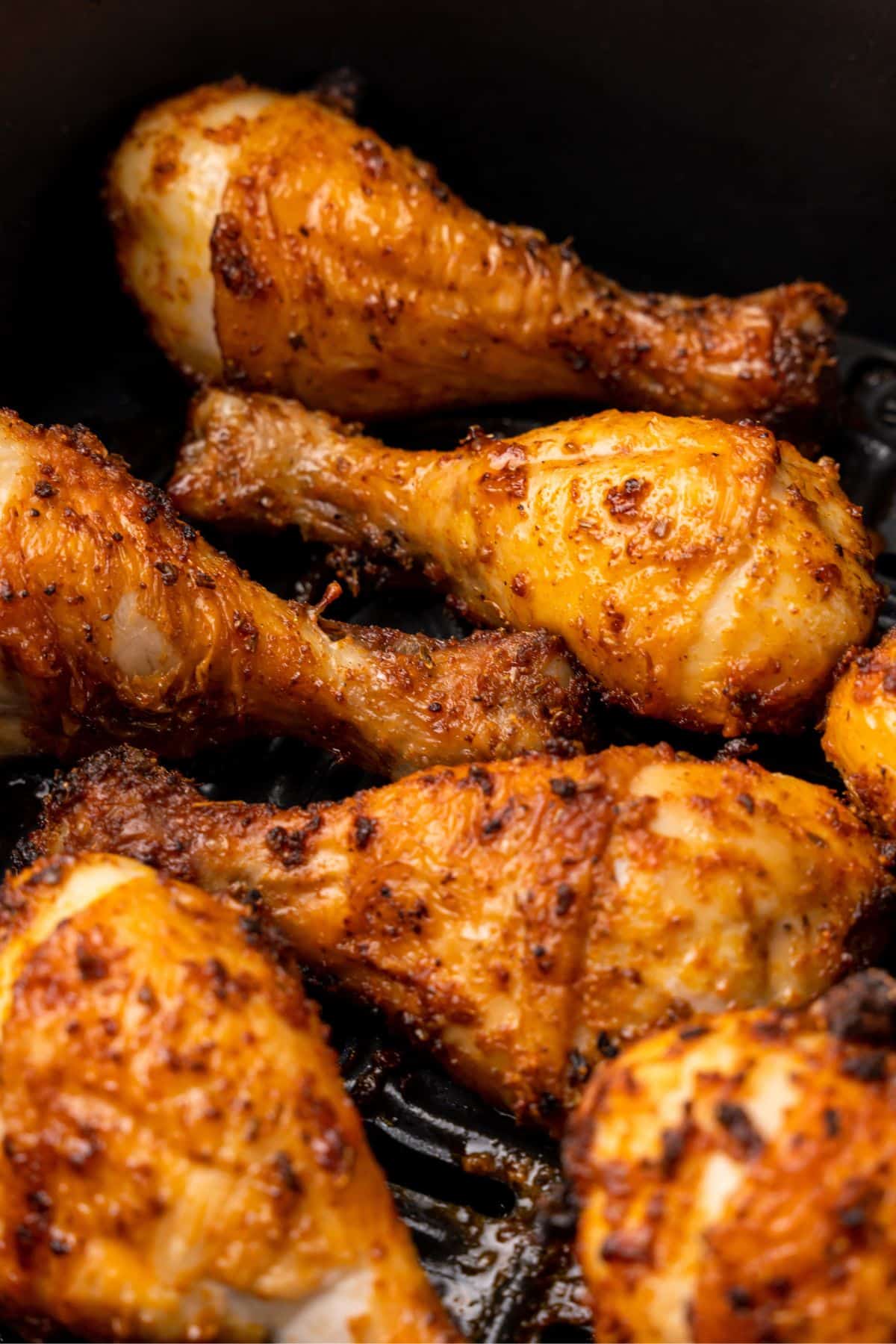 Closeup of the chicken legs in the air fryer basket all done air frying.