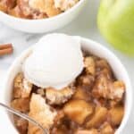 Overhead image of two bowls of apple cobbler with ice cream on top.