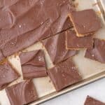 Saltine cracker toffee on baking tray, partially sliced into squares.