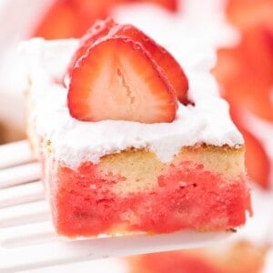 Close up view of a slice of jello poke cake to see the jello inside the cake.