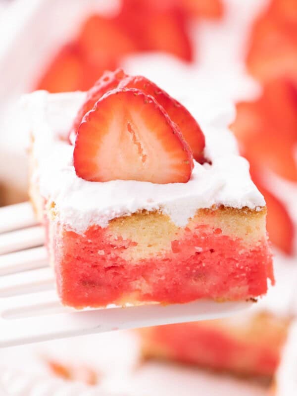 Close up view of a slice of jello poke cake to see the jello inside the cake.