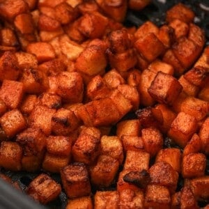 Close up of cooked butternut squash in an air fryer basket.