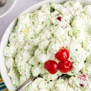 Large serving bowl of Watergate salad with a serving spoon in it.