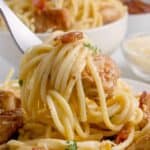 Close up of a fork lifting a bite of pasta on it.