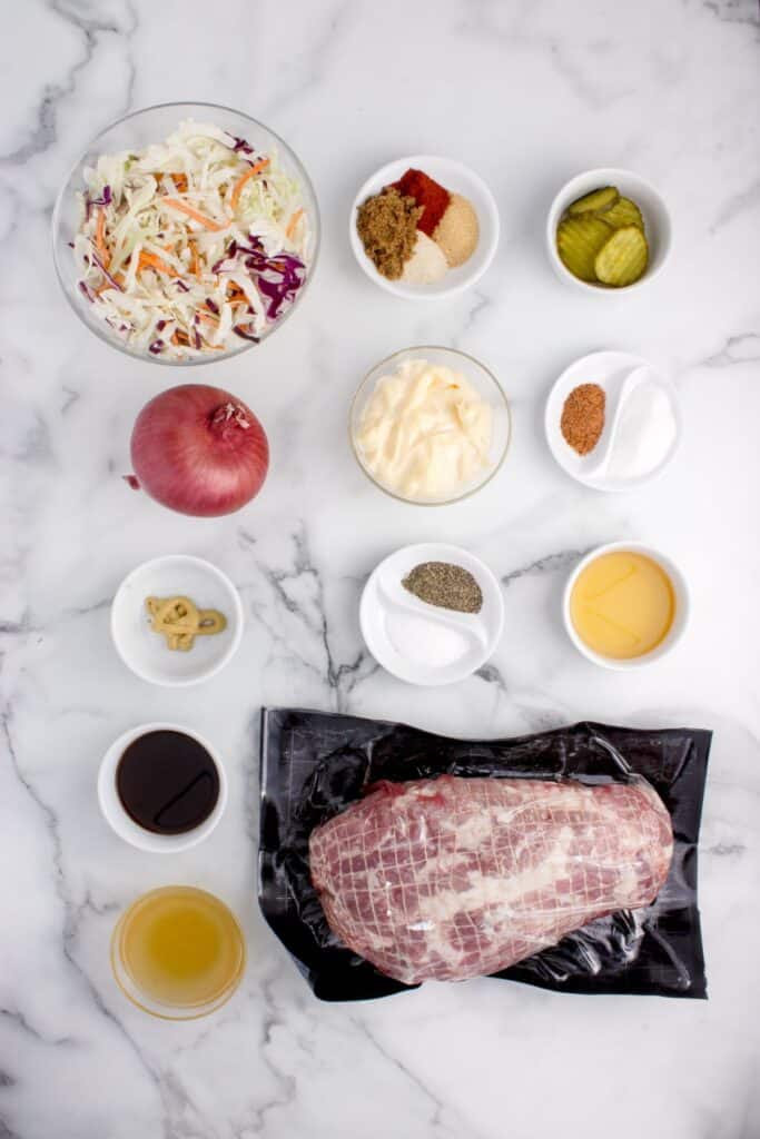 Ingredients for pulled pork sandwiches: Boneless Pork Shoulder - pork butt roast, chicken broth, worcestershire sauce, apple cider vinegar, onion, garlic powder, garlic powder, paprika, brown sugar, salt, and ground black pepper, and homemade cajun coleslaw.