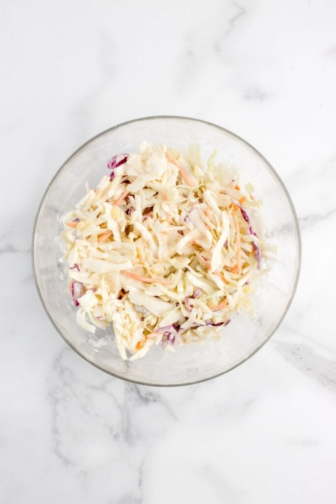 Glass bowl with coleslaw in it.