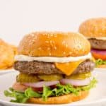 Bison burgers on white dinner plates.