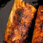 Two cooked mahi mahi fillets in a cast iron pan