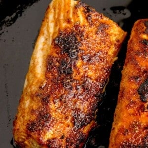 Two cooked mahi mahi fillets in a cast iron pan