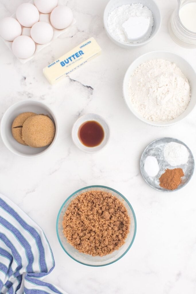 Ingredients for coffee cake muffins: all purpose flour, brown sugar, cinnamon, butter, baking powder, baking soda, ground cinnamon, milk, eggs, vanilla extract, and powdered sugar.