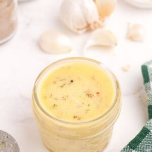 A glass jar of homemade garlic parmesan sauce.