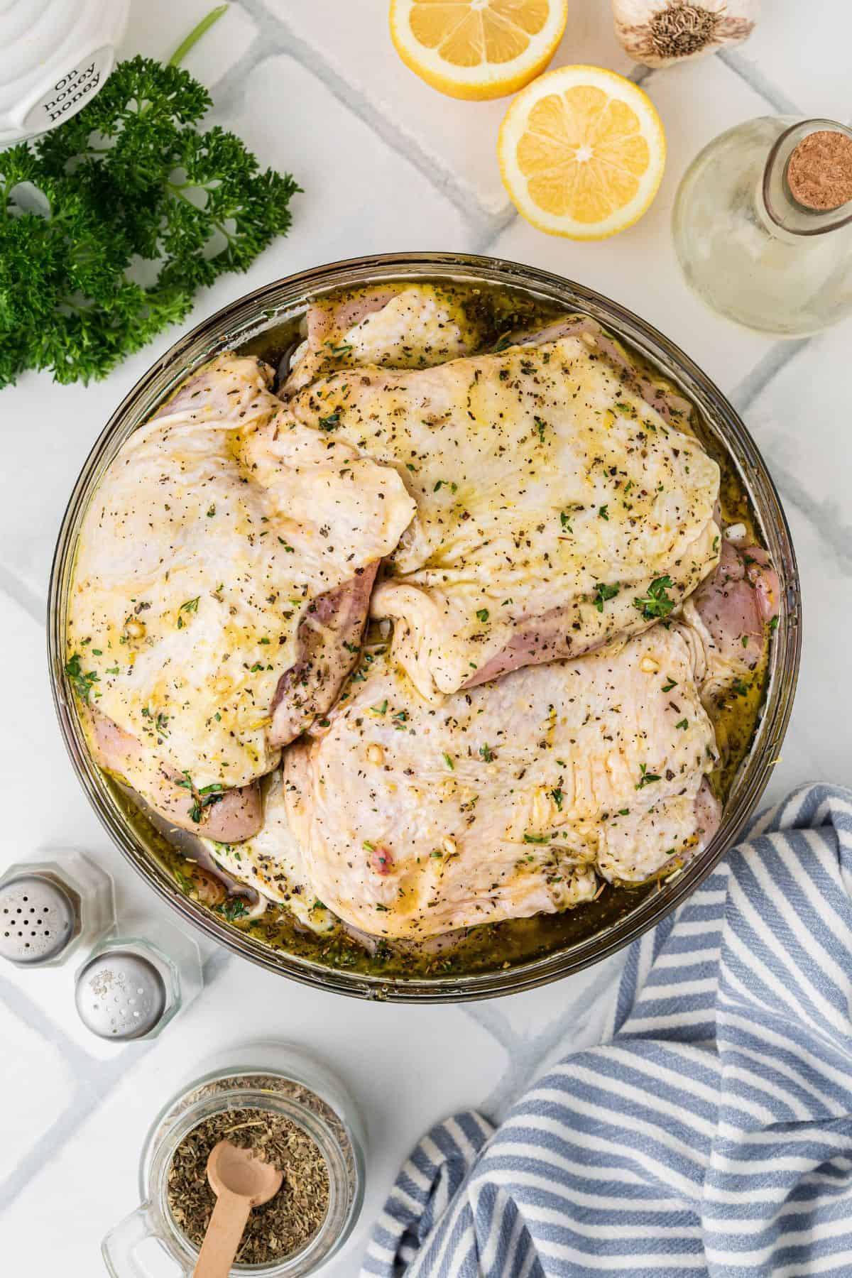 Marinated chicken thighs in a bowl.