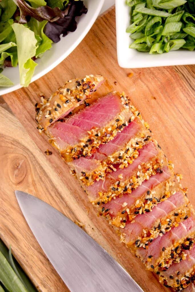 Completed, sliced tuna steak on a cutting board.