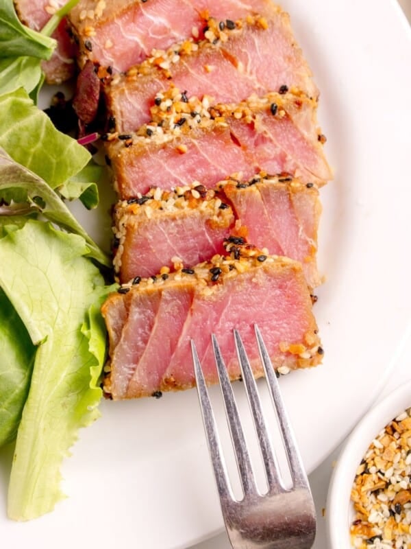 A white dinner plate with sliced tuna steak.