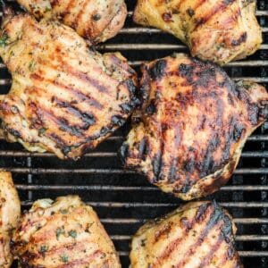 Grilling chicken thighs with the grill marks and slight char marks on them.