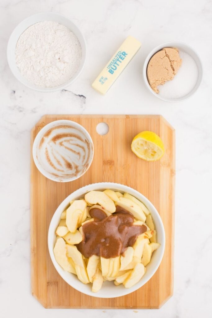 Sliced apples with brown sugar, lemon juice, and cinnamon mixture on top.