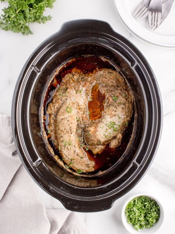 Cooked pork tenderloin in the crock pot insert.
