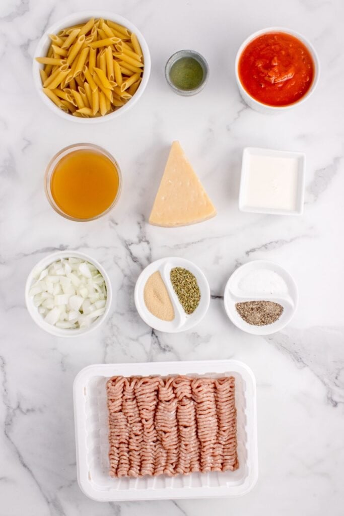 Ingredients for ground turkey pasta: penne pasta, olive oil, onion, ground turkey, salt, black pepper, garlic powder, Italian seasoning, marinara sauce, chicken stock, heavy cream, and Parmesan cheese.