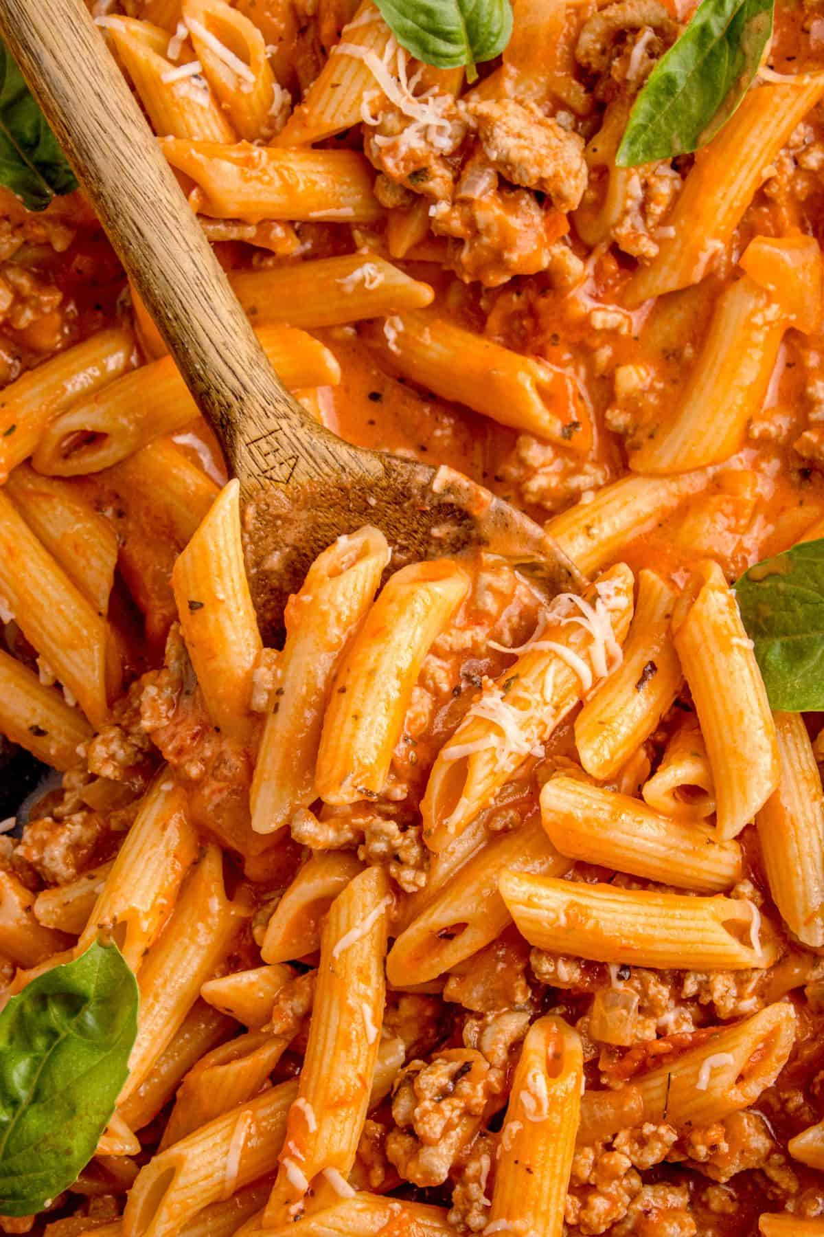 Turkey pasta with a wooden spoon lifting a serving.