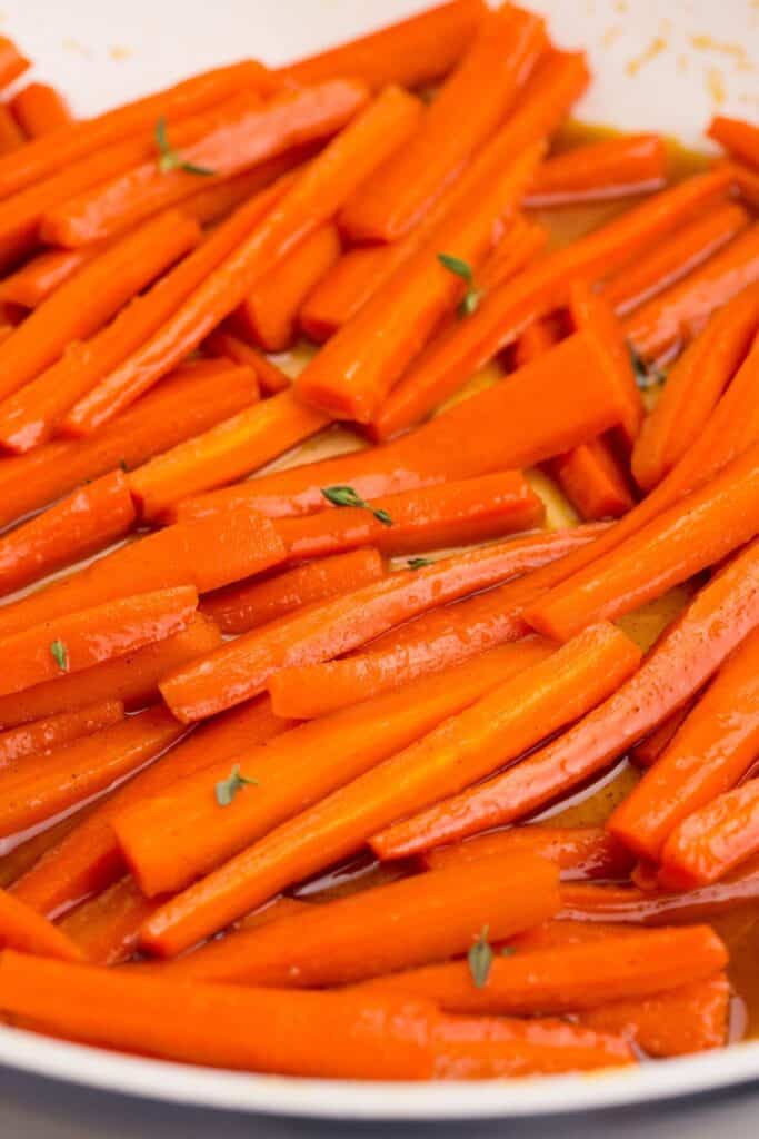 Maple carrots cooking in a skillet.