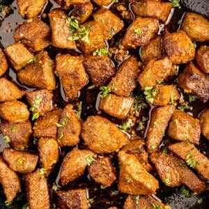 Completed steak bites in garlic butter.