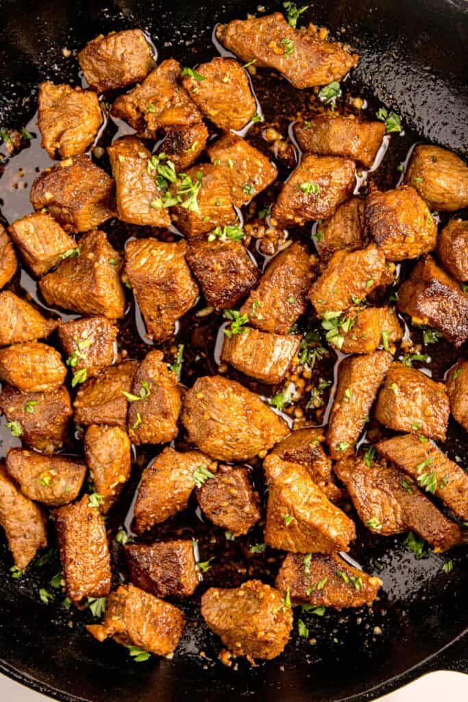Completed steak bites in garlic butter.