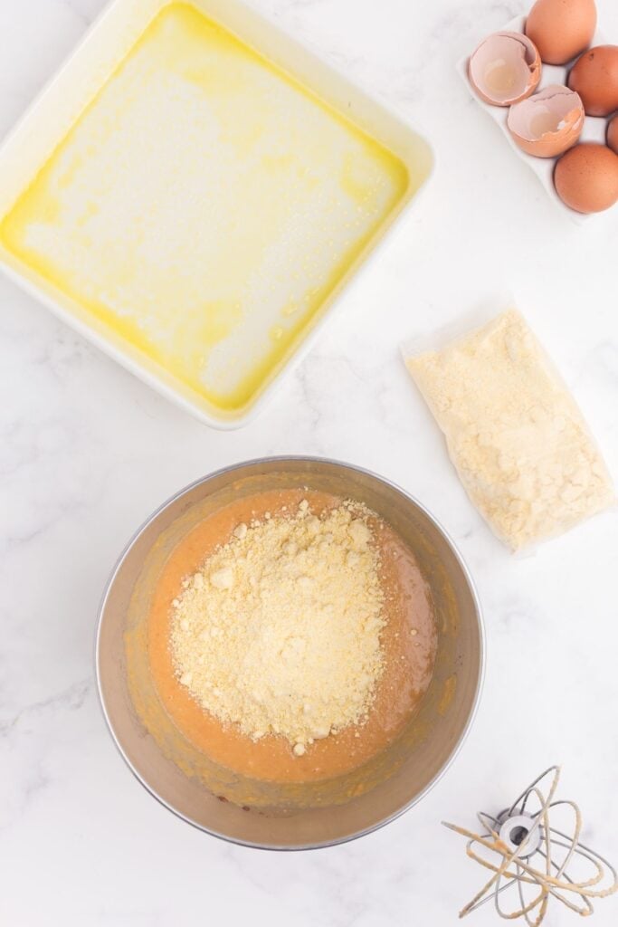 Cornbread batter with cornbread mix added to the mixing bowl.