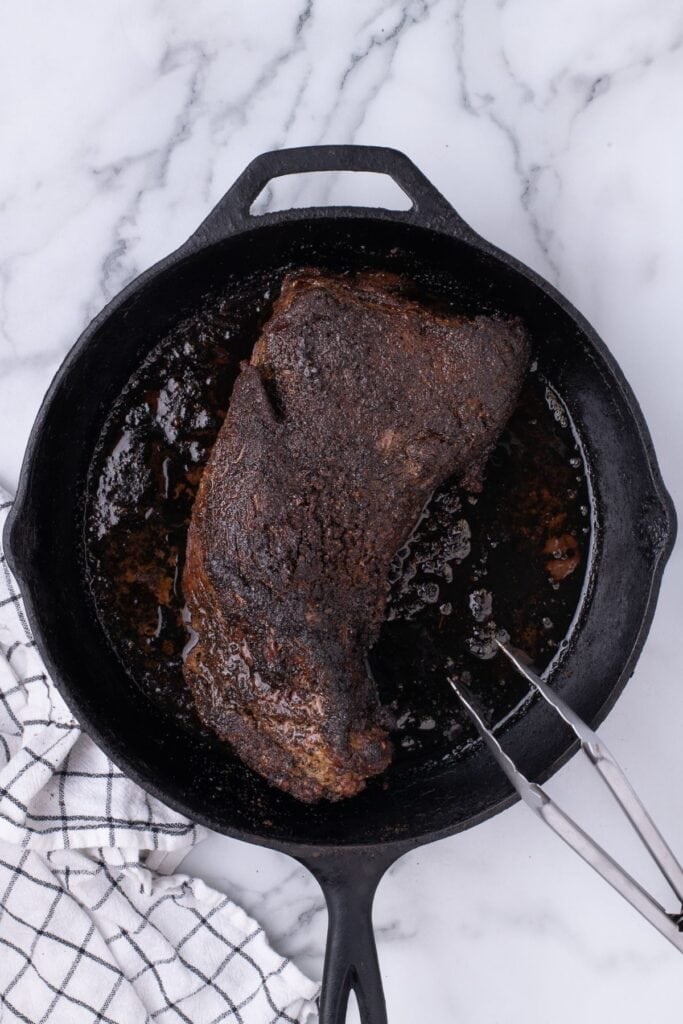 Tri tip seared in a cast iron pan.