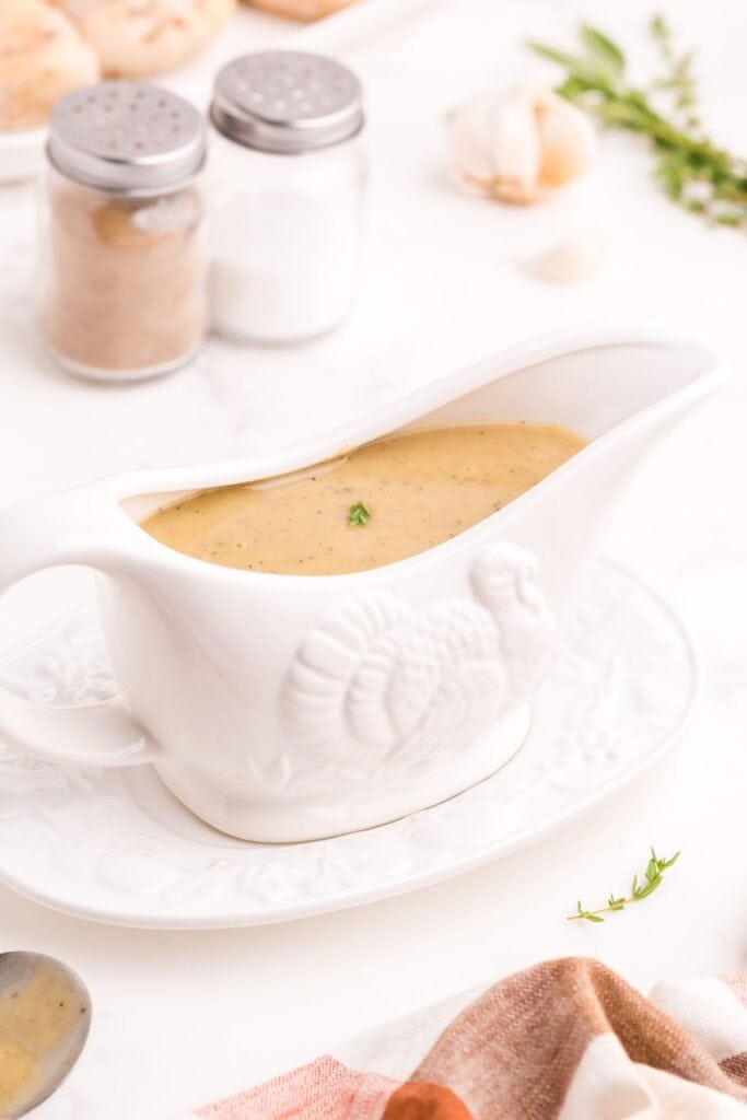 A white gravy boat with homemade turkey gravy in it.