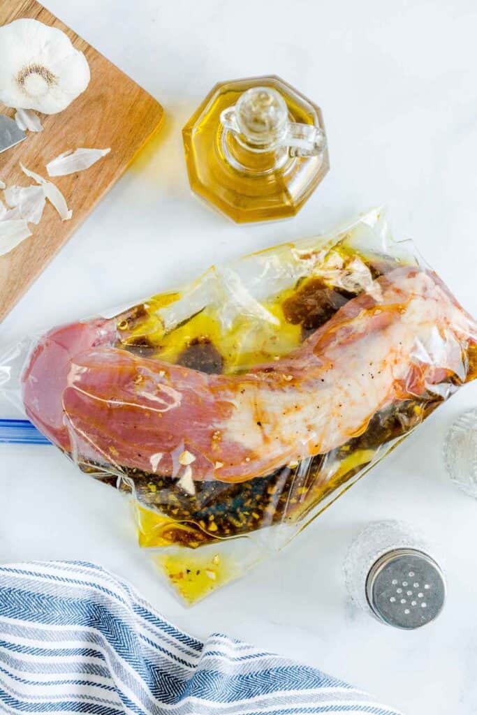 Pork tenderloin being marinaded in a Ziploc bag.